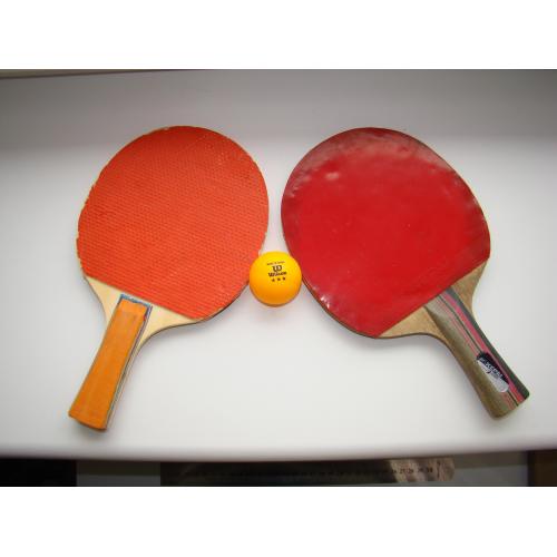Теннисные ракетки и шарик для игры в настольный теннис.