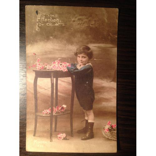 Французская фотооткрытка. Мальчик возле столика с цветами.