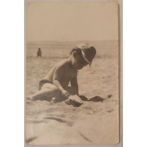 Фото ребенок на берегу играет в песочке