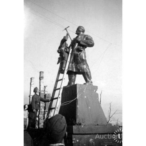 Солдат вермахта бьет кайлом памятник Ленину.