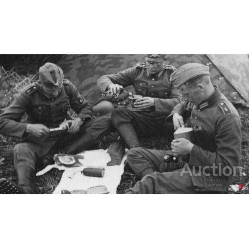 Три солдата вермахта принимают пищу.